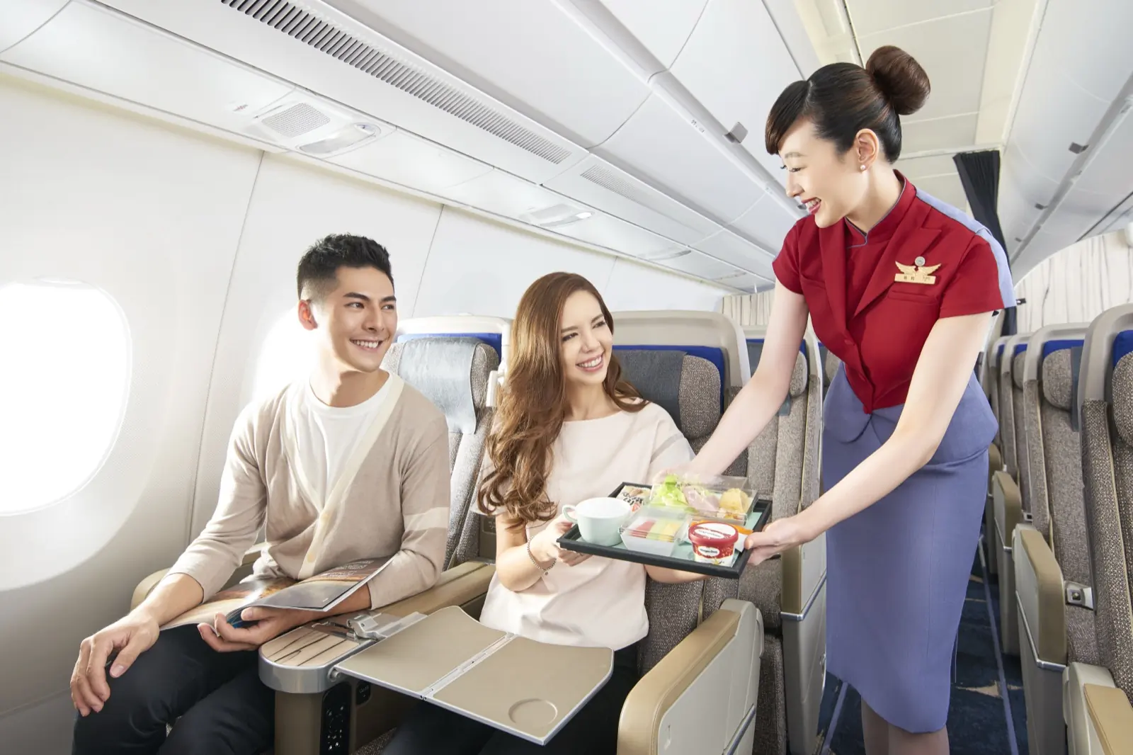 A China Airlines cabin crew member serving a meal to passengers